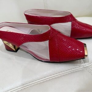 Red heels sandals with closed toes with gold detail and white net on the sides.